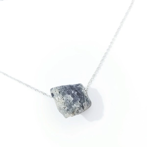 Detailed view of irregular grey raw crystal pendant with natural texture on silver chain