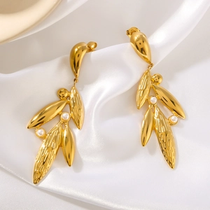 Leaf earrings in 18k gold plated steel with pearls on elegant white silk background