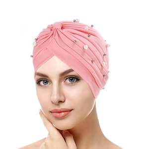 Detail of pink pleated turban hat featuring elegant faux pearls and silver bead accents