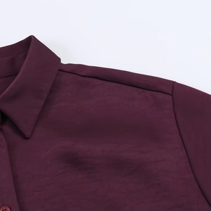 Detailaufnahme des dunkelroten Satinoberteils mit klassischem Kragen und feiner Textur