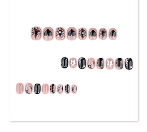 Macro detail of Y2K gothic press-on nails with pink black contrast and heart patterns