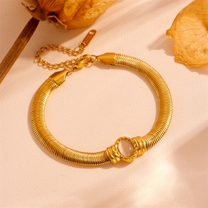 Detailed close-up of gold stainless steel snake chain bracelet with cat-eye stone inlay