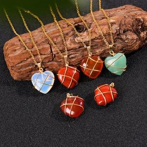 Collana con pendente a cuore in cristallo naturale e filo dorato su sfondo nero