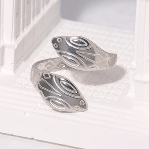 Detailed close-up of a silver double-headed snake open ring on a white artistic display
