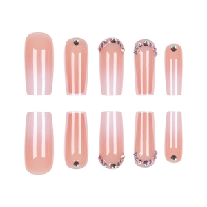 Pink and white gradient press-on nails with colorful rhinestones in a long coffin shape