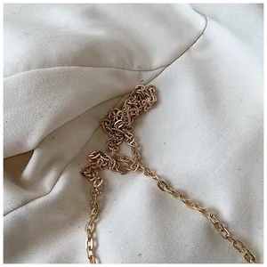 Detail of elegant gold chain strap on textured fabric for acrylic evening bag