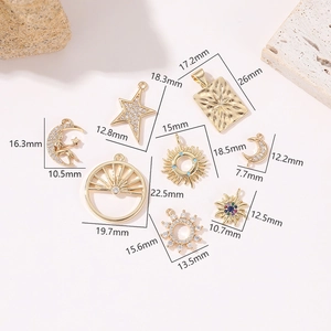 Macro detail of gold celestial pendants with sun, moon shapes and zircon inlays for DIY