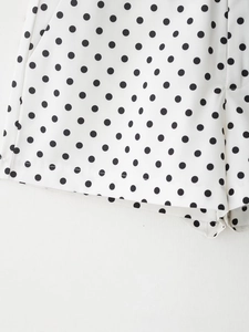 Détail du short blanc à pois noirs montrant les coutures soignées et le tissu lisse