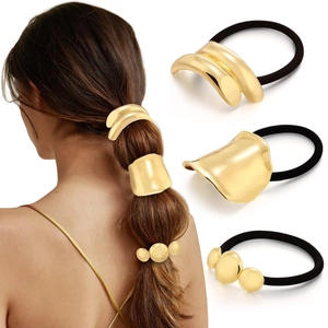 Detailed view of three gold alloy ponytail cuffs with textured and layered metal designs
