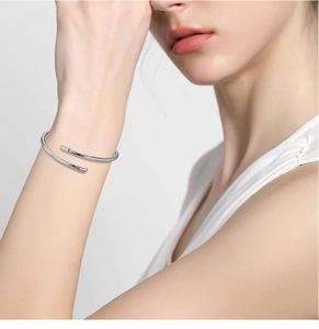 Close-up of minimalist 3mm S925 sterling silver open bangle worn on a model wrist