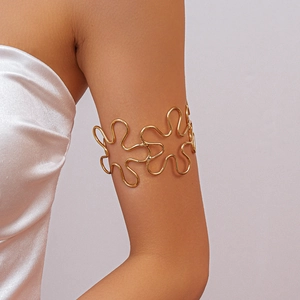 Detailed view of a gold hollow flower upper arm cuff featuring wavy metallic petal design