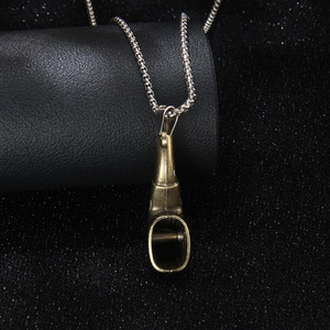 Collier pendentif sifflet en bronze vintage avec chaîne à billes argentée sur fond noir