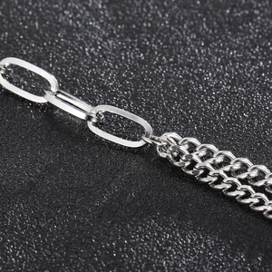 Macro detail of silver stainless steel Cuban link and oval chain joint with OT clasp