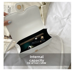 Detail showing internal capacity of the white crossbody bag with daily essentials inside