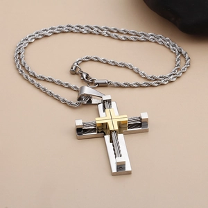 Close-up of silver steel cross pendant with gold inlay and steel wire on twist chain
