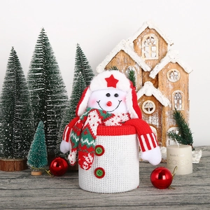 Charming snowman knitted Christmas gift bag with star hat and festive winter decor background