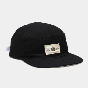Detail of black cotton 5-panel camp cap featuring flat brim and Old New woven label