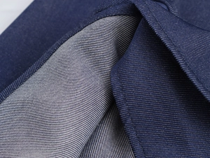 Vue macro détaillée de la texture du denim bleu foncé et des coutures de bord nettes