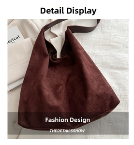 Detailed texture of dark reddish-brown suede hobo bag with wide leather shoulder strap