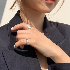 Close-up of minimalist layered 925 silver rings on finger with artistic light and shadows