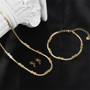 Macro detail of 18k gold plated infinity necklace and bracelet set on black silk