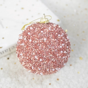Detail of rose gold Christmas ball featuring shimmering sequins and faux pearls