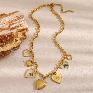 Dettaglio della collana placcata oro 18K con ciondoli a cuore e quadrifoglio con fiori