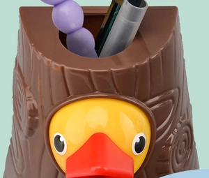 Detail of woodpecker toy showing the tree stump storage container with duck relief