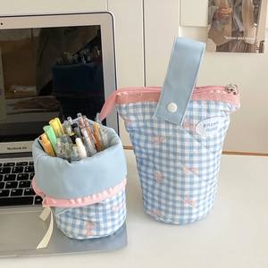 Close-up of quilted plaid pencil case with pink bow prints and portable blue strap handle