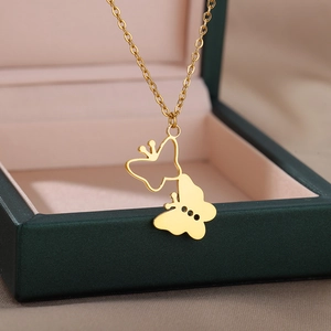 Detail of 18k gold heart butterfly pendant with delicate cross chain on jewelry box