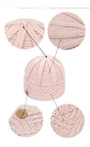 Detail view of the pink knit beanie crown closure and textured diamond pattern weaving