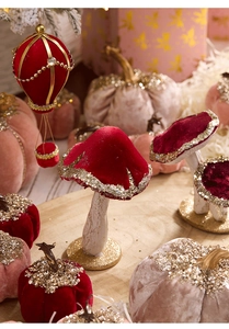 Detail of red and pink velvet Christmas mushrooms and pumpkins with sparkling gold glitter