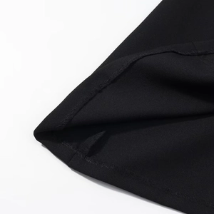 Détail de l'ourlet de la robe noire avec une finition de couture à double piqûre