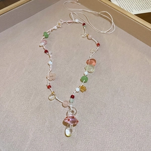 Detail of beaded necklace featuring a glass mushroom pendant and colorful resin beads