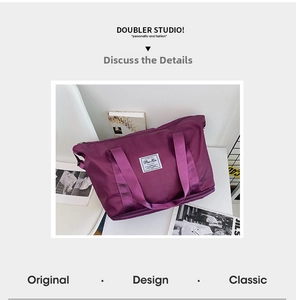 Detail of purple waterproof travel bag showing woven handles and reinforced bottom zipper
