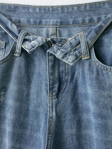 Dettaglio ravvicinato della vita di jeans blu con cerniera in metallo e cuciture