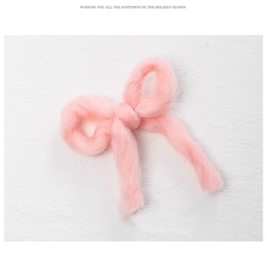 Close-up of a soft pink handmade felt bow decoration for Christmas tree ornaments