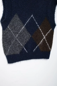 Nahaufnahme der flauschigen Rautenmuster-Textur der dunkelblauen Strickweste