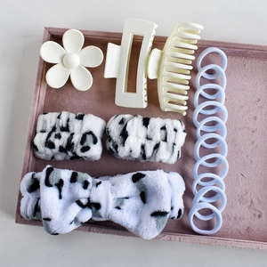 Detail of 16-piece hair accessory set with plush bow headband and floral clips in tray