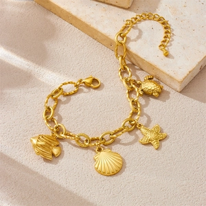 Gold plated ocean theme charm bracelet with starfish turtle and seashell on stone