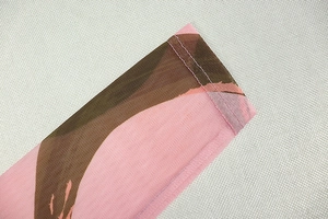 Macro detail of high-density mesh sleeve with abstract pink and brown print pattern