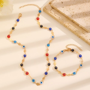 Flat lay of evil eye jewelry set with gold chains and colorful beads on a beige base