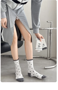 Vue détaillée de chaussettes en coton blanc à pois gris avec bordures à volants douces