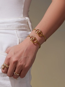 Detail eines 18k Gold-Armbandes mit Zirkon-Doppelringen und elegantem Perlenring am Modell