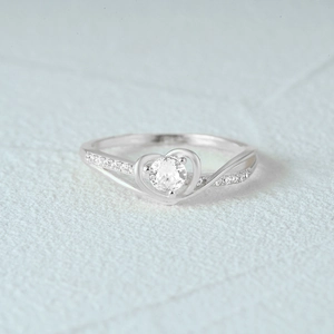 Macro shot of silver S925 ring featuring heart-shaped setting and round diamond side stones