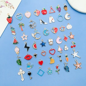 Flat lay of colorful enamel alloy charms featuring fruit and animal shapes on blue base