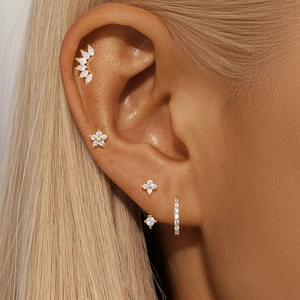Detail of four-piece s925 silver gold stud earring set with zircons on model ear