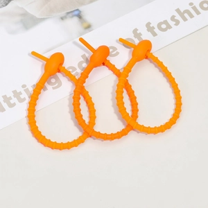 Three orange silicone cable ties in a looped lock state on a modern white background