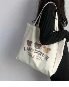 Detail view of large canvas tote bag with bear embroidery and thick texture