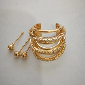 Detailed view of 4-piece gold geometric jewelry set including layered cuff and ball studs